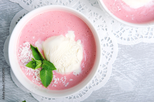 Cold creamy strawberry soup with a scoop of ice cream and mint