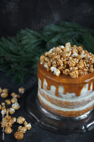 Caramel party cake with popcorn on a dark background, Selective focus, Vertical, Christmas party