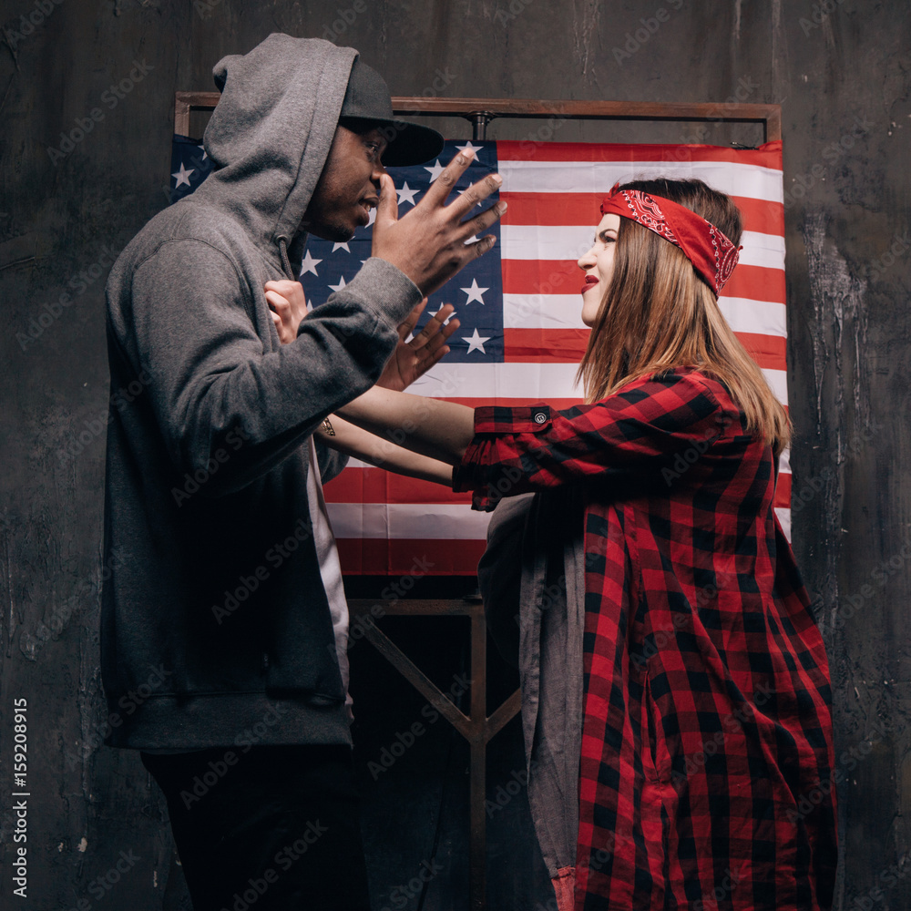 Man and woman in conflict on US flag backdrop. Divorce in american family. Wife and husband with little baby on USA national flag background. Social problem, child custody, youth pregnancy concept