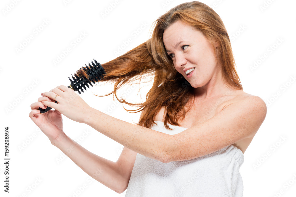 Woman combing tangled red hair after shower on white background Woman combing tangled red hair after shower on white background