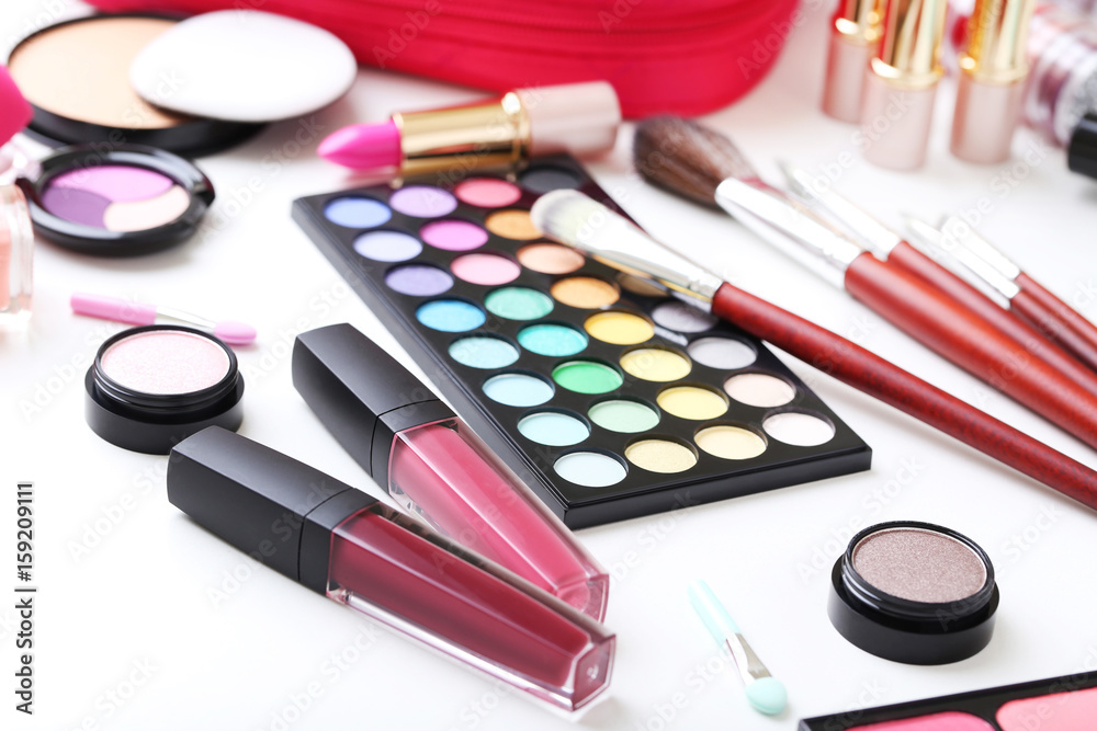 Different makeup cosmetics on white table Different makeup cosmetics on white table