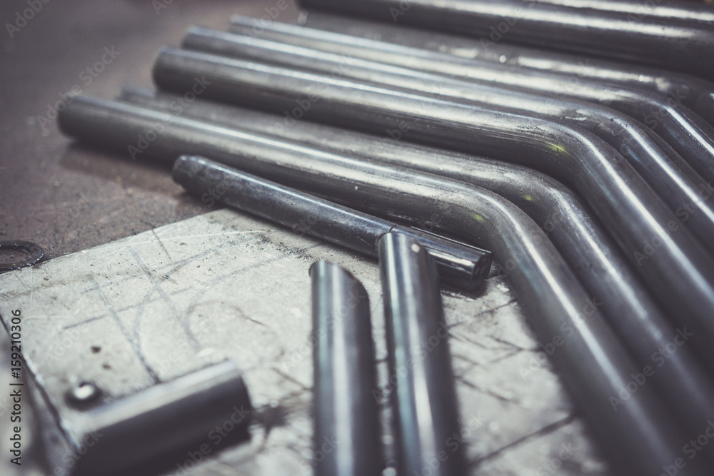 Bent steel pipe on a work bench.