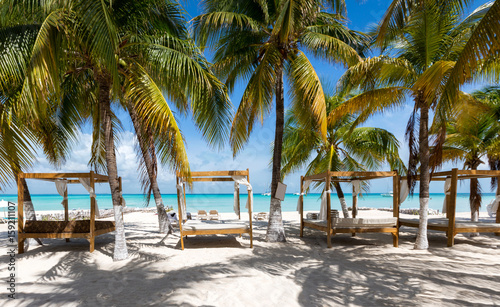 Luxus Sonnenbetten am karibischen Strand mit Palmen in Mexiko