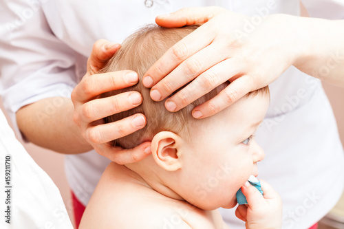 Infant receiving osteopathic treatment of her head
