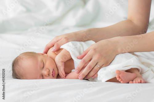 Newborn baby. Mother gently strokes her child's hand