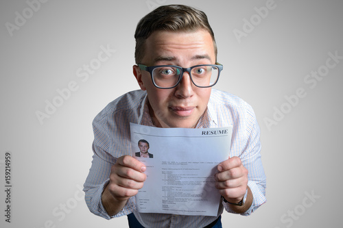 Funny guy (student, businessman)  looking for a job and holding his resume