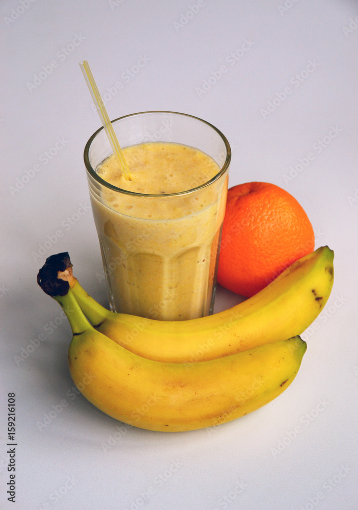 A composition of bananas and orange and a glass with smoothies A composition of bananas and orange and a glass with smoothies