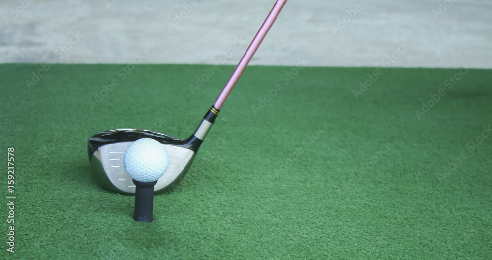 Obraz premium golf ball on tee with driver club, in front of driver, driving range