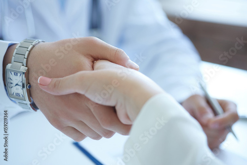 Male doctor shaking hands with patient. Partnership  trust and medical ethics concept. Handshake with satisfied client. Thankful handclasp for excellent treatment.