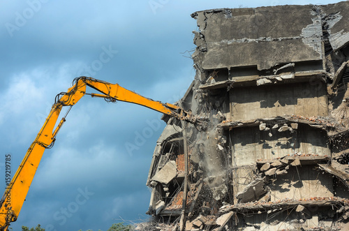 Heavy equipment being used to tear tearing down building construction