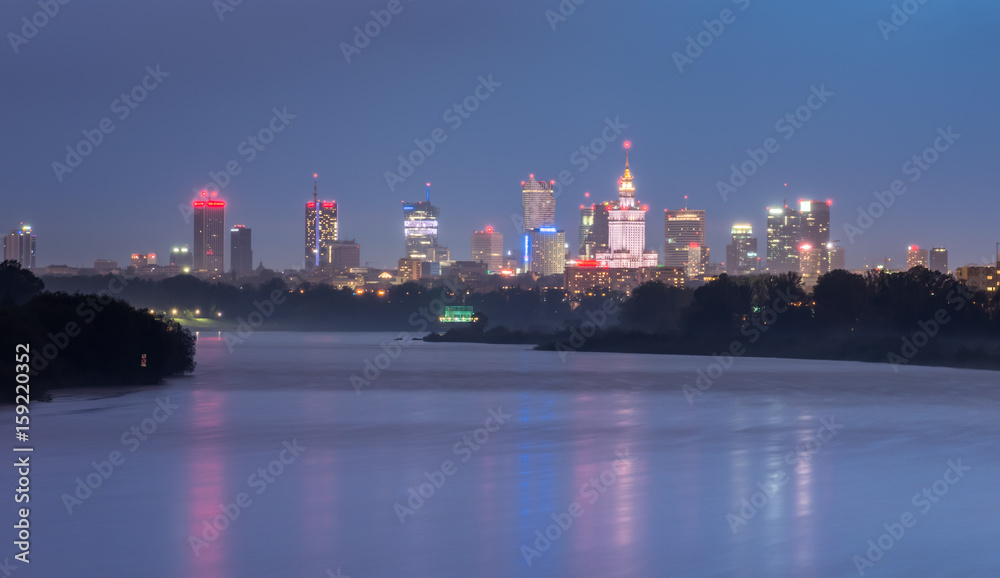 Colorful night panorama of Warsaw skyline, Poland, over Vistula river in the night
