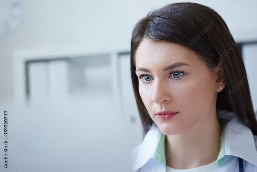Beautiful female medicine doctor sitting at the table and working on desktop computer. Beautiful female medicine doctor sitting at the table and working on desktop computer.