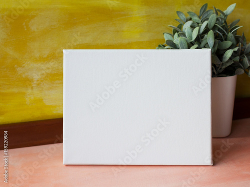 Mock up poster in the bright interior. Horizontal blank canvas against the yellow wall. photo