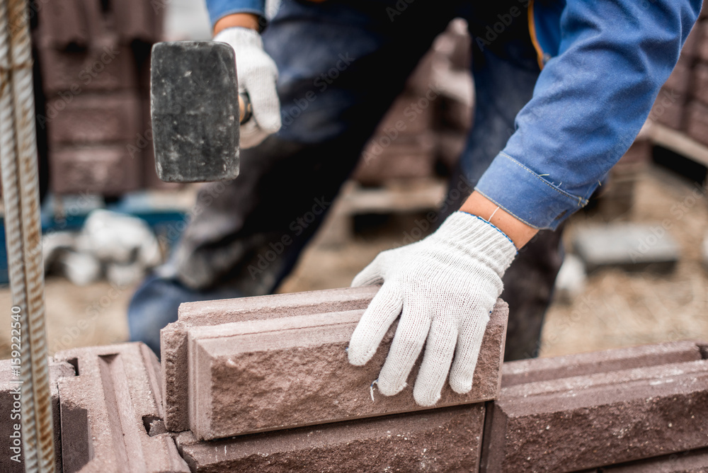 Bricklayer putting down another row of bricks in site Bricklayer putting down another row of bricks in site