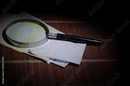 Chinese abacus and Magnifying glass, business concept on a dark background photo