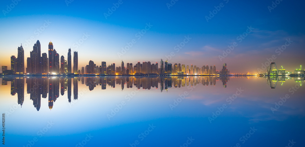The beauty panorama of skyscrapers in Dubai at dusk with clear reflection.