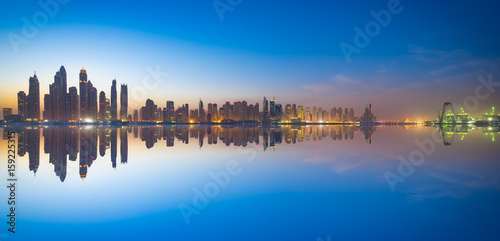 The beauty panorama of skyscrapers in Dubai at dusk with clear reflection.