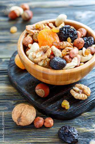 Dried fruit and mixed nuts in a wooden bowl.