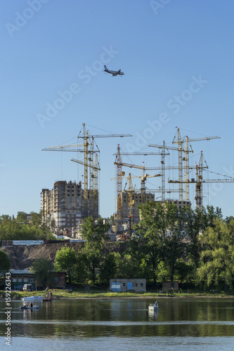 Plane flies near the construction site of houses