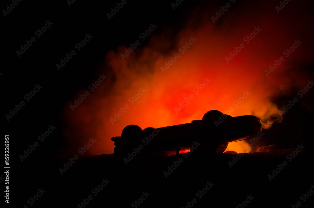 Burning car on a dark background. Car catching fire, after act of vandalism or road indicent