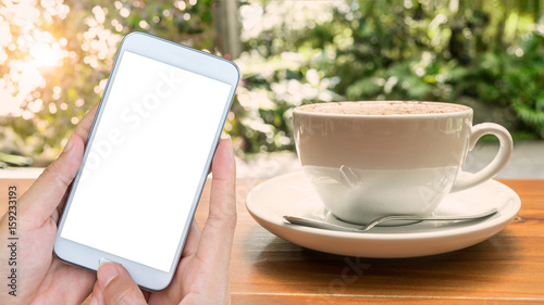 hand holding smartphone with blank screen mobile and coffee cup
