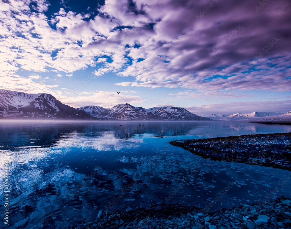 landscape of the Arctic Ocean and reflection with blue sky and winter mountains with snow  , Norway, Spitsbergen, Longyearbyen, Svalbard