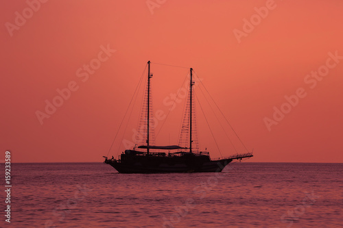 Beautiful red sunset with a sailboat sailing