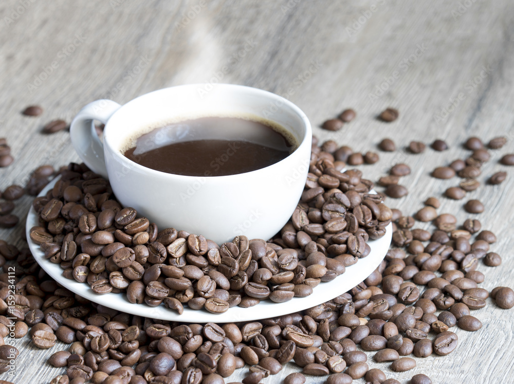 Fototapeta premium Coffee cup in the middle of coffee beans