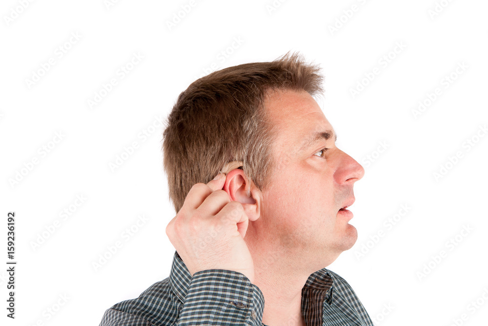 Middle-aged deaf man testing a hearing aid Middle-aged deaf man testing a hearing aid