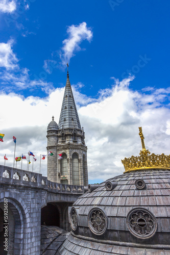 Basilica of our Lady of the Rosary and flags of different countries against the blue sky. Lourdes  France