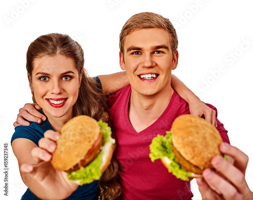 Couple eating fast food. Man and woman eat hamburger with ham . Friends holding two burder junk on white background isolated. Loving couple prefers fast food to homemade dinner.