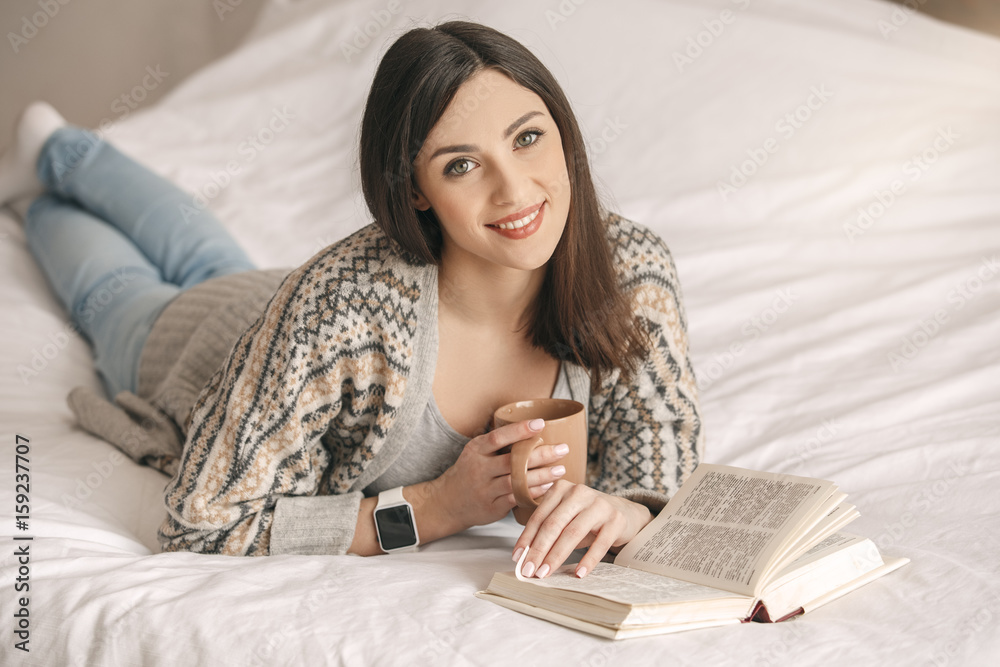 Young woman lie on bed with a book rest Young woman lie on bed with a book rest