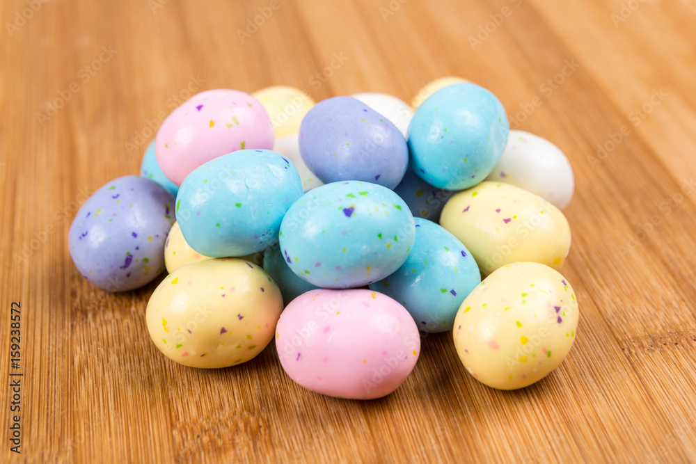 Pastel chocolate malted eggs on a wood background