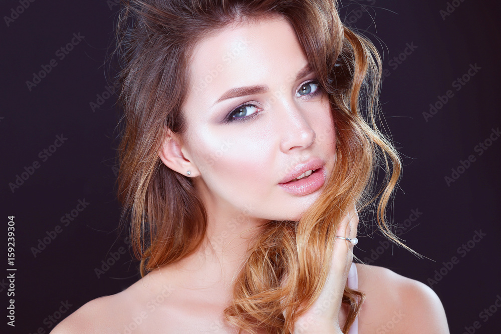 Fototapeta premium Portrait of beautiful young woman face. Isolated on dark background