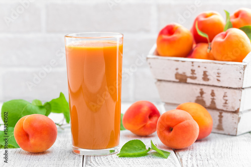 Apricot juice and fresh fruits with leaves