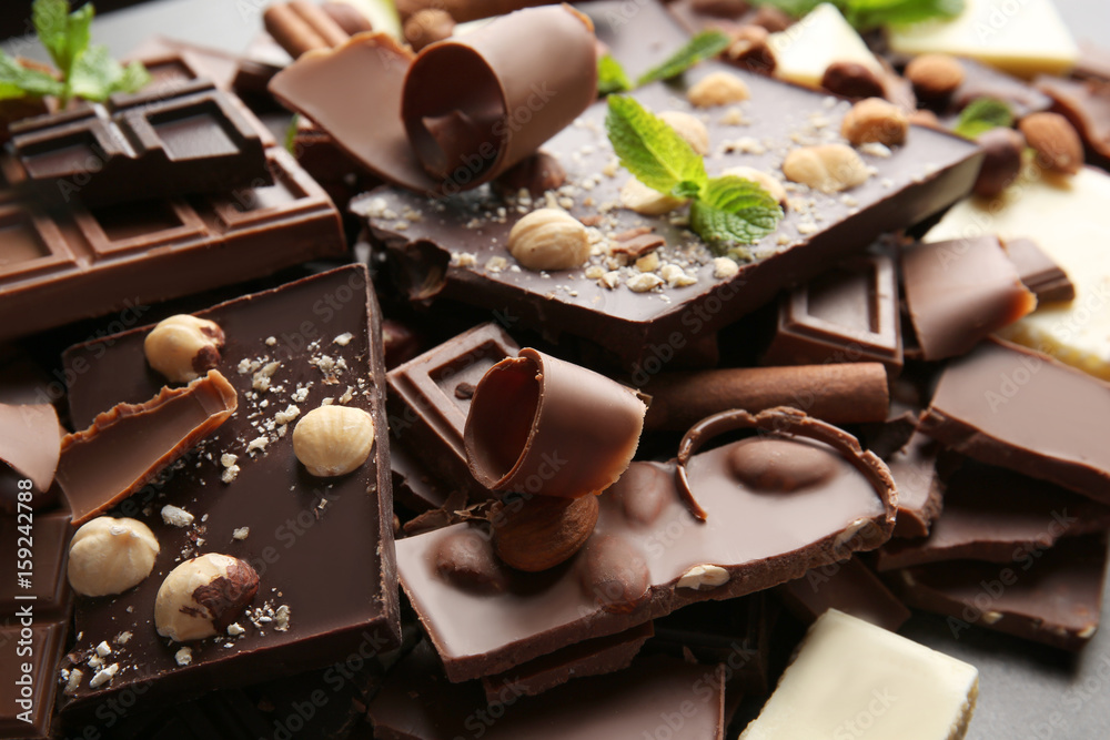 Heap of broken chocolate pieces with mint, close up - obrazy, fototapety, plakaty 