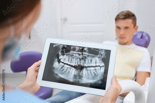 Dentist looking at X-ray im...