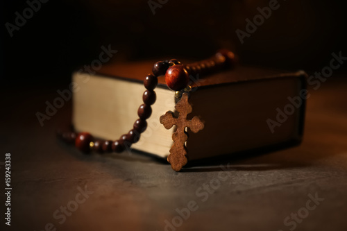 Bible with rosary on dark background © Africa Studio