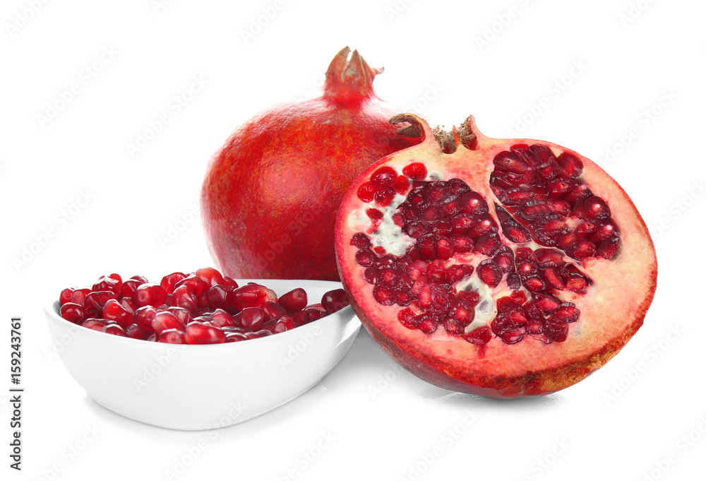 Pomegranate seeds in bowl and sliced fruit on white background. Aphrodisiac food for increasing sexual desire Pomegranate seeds in bowl and sliced fruit on white background. Aphrodisiac food for increasing sexual desire
