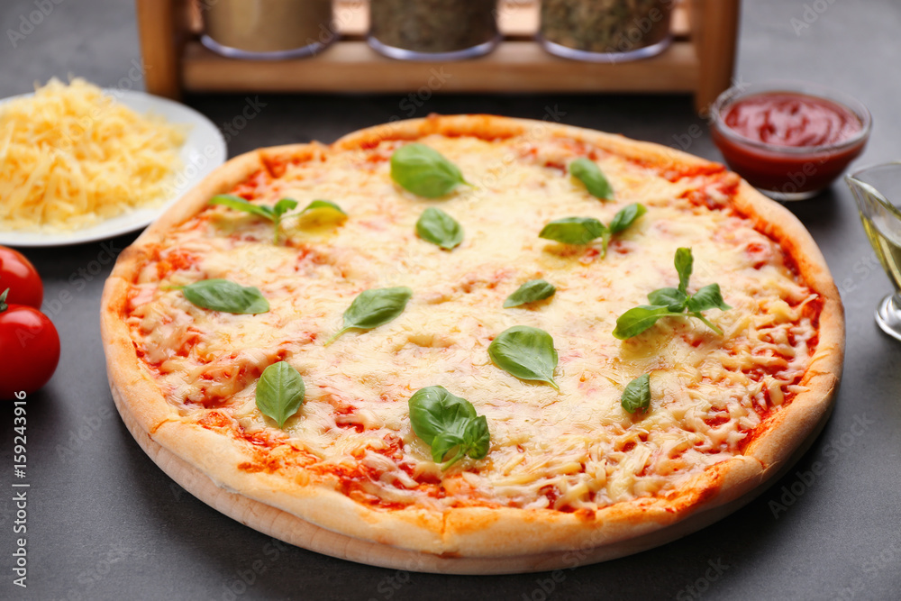 Delicious pizza with melted cheese and basil on table Delicious pizza with melted cheese and basil on table