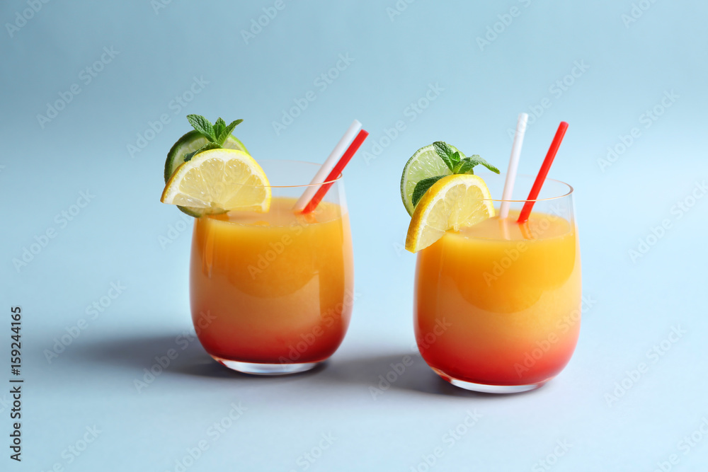 Fototapeta premium Glasses of Tequila Sunrise cocktail on light background