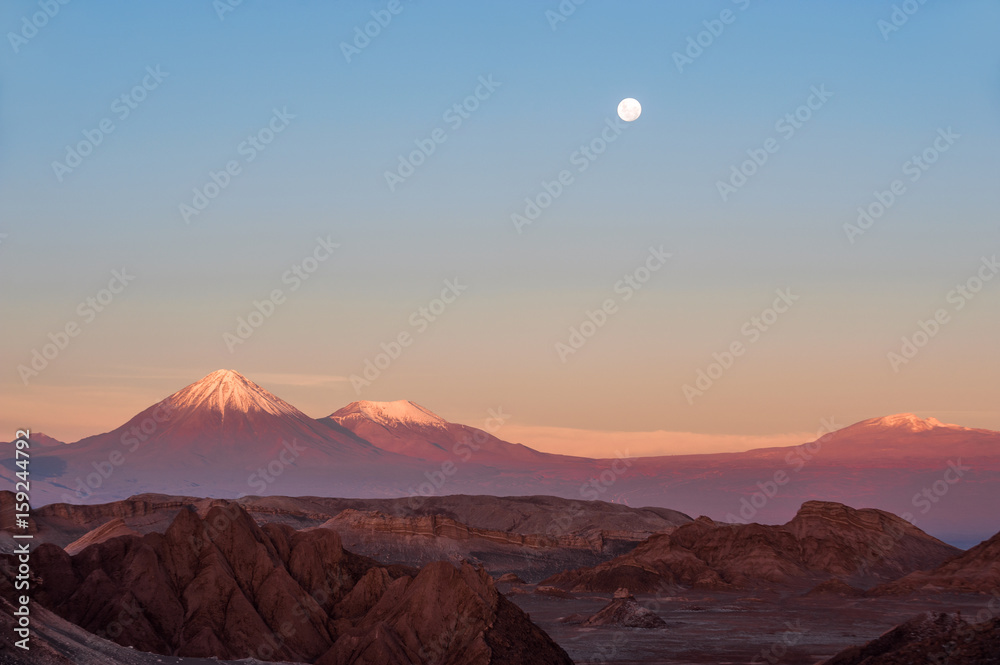 Full-moon in the Moon Valley. Volcanoes Licancabur and Juriques, west of San Pedro de Atacama, Chile in the Cordillera de la Sal, in the Atacama desert of Chile