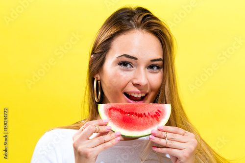 Happy young woman holding watermelon