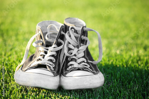 Pair of gumshoes on green grass, closeup