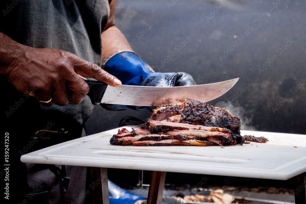  Cook slices beef fresh out of the smoker at a local food festival