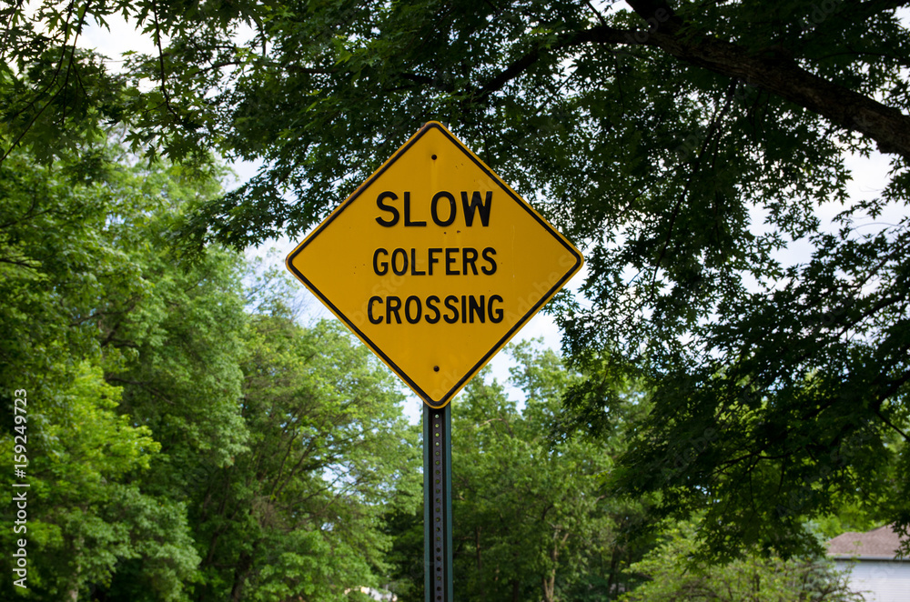 slow golfer crossing warning sign on a neighborhood street