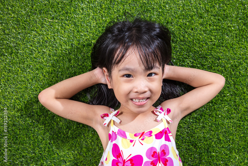 Asian Chinese little girl lying on the grass Asian Chinese little girl lying on the grass