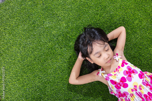 Quadro em tela Asian Chinese little girl lying on the grass