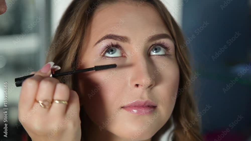 Make-up artist putting on make-up on model's eyes. Eye make-up. Make-up artist putting on make-up on model's eyes. Eye make-up.
