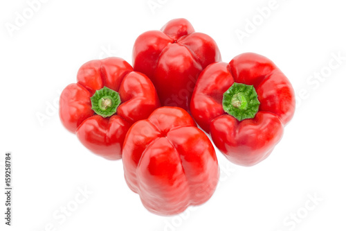 Four red bell peppers on a light background